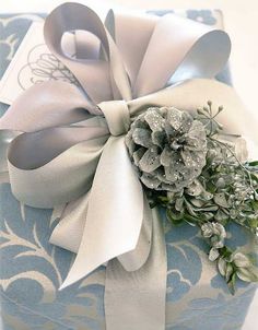 a close up of a present wrapped in blue and white paper with flowers on it