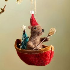 a christmas ornament with a mouse in a boat