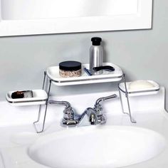 a white sink sitting under a mirror next to a shelf with two items on it