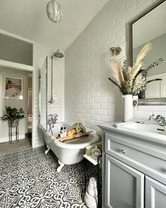 a bath room with a tub a sink and a mirror on the wall in it