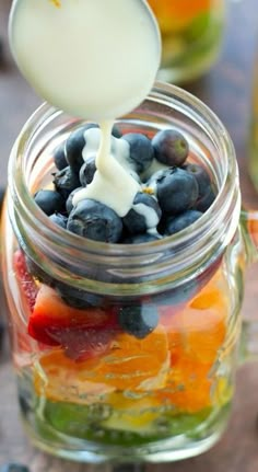 fruit salad in a jar being drizzled with milk