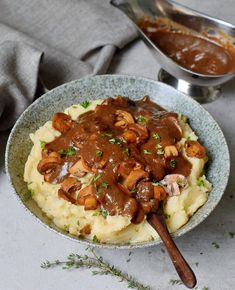 mashed potatoes with mushrooms and gravy in a bowl