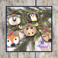 christmas ornaments made out of wood and decorated with woodland animals, pine branches and flowers