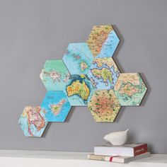 hexagons with maps on them are mounted to the wall above a mantle