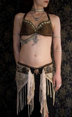 a woman in a bra and skirt with chains on her waist