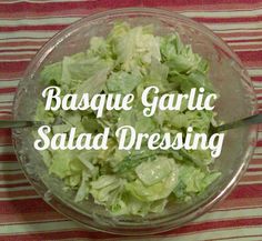 a salad in a bowl with the words basque garlic salad dressing