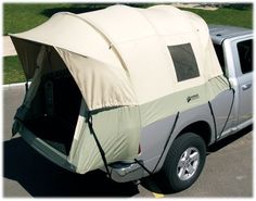 a truck with a tent attached to it's bed parked in a parking lot