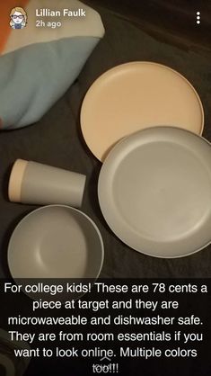 there are several white plates and cups on the table with an orange pillow in the background