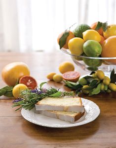 there is a piece of bread on a plate with lemons and grapefruit in the background