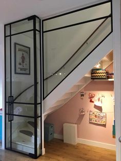 a room with a stair case in the corner and some pictures on the wall next to it