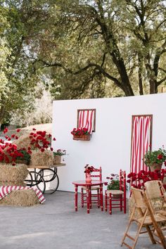 red and white striped chairs, hay bales, and flowers in front of a house