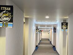 an empty hallway with signs on the walls and carpeted flooring in front of them