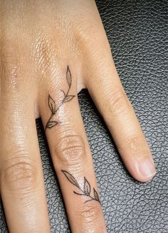 a woman's hand with a small tattoo on it