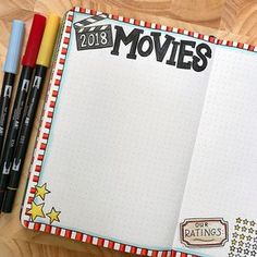 an open notebook with the words movies written on it and two markers next to it