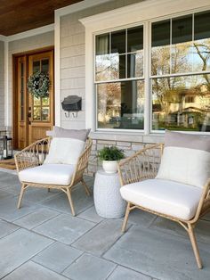 two wicker chairs sitting on the front porch