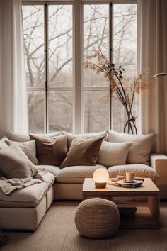 a living room filled with furniture and a large window covered in lots of natural light