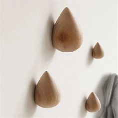 three wooden pegs are hanging on the wall