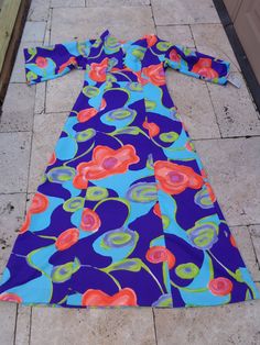 1970's Hawaiian Print Maxi Dress by Tori Richard Honolulu Polyester Fabric/Feels like Combed Cotton Purple, Blue, Pink Orange and Green Multicolor Fabric 4 Front Decorative Buttons 23 Inch Back Zipper SIZE: Medium/Large MEASUREMENTS (in inches): Shoulder to Shoulder from the back 20 Bust: 38 Waist: 36 Underarm to hem 44 Underarm to cuff 13 Sleeve Openings 10 Neck Opening: 26 Front 4 Inch V Split Back of the neck to hem 53 INTERNATIONAL CUSTOMER?? Please email for Shipping Info Retro V-neck Lined Maxi Dress, Retro Blue Spring Maxi Dress, Vintage Blue Maxi Dress For Spring, Blue Retro Dress With Retro Print, Retro Blue Maxi Dress For Spring, Retro Blue Maxi Dress For The Beach, Blue Retro Maxi Dress For Spring, Blue Vintage Maxi Dress For Spring, Mid-century Blue Spring Dresses