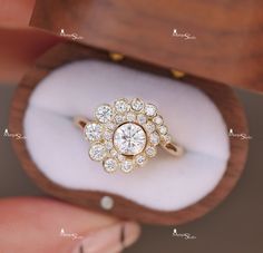 a close up of a diamond ring in a wooden box