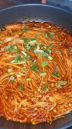 a pan filled with spaghetti and sauce on top of a stove