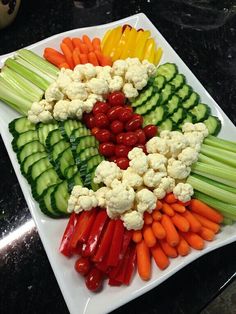 there is a platter full of vegetables on the table, including cauliflower and carrots