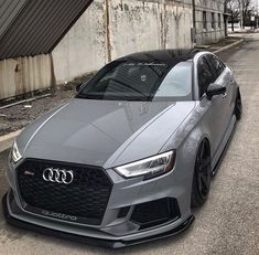 a grey car parked in front of a building