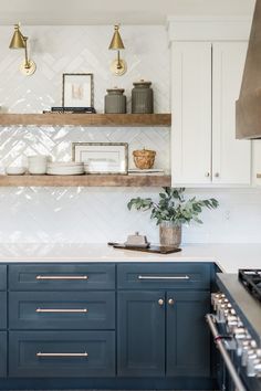 a kitchen with white and blue cabinets, gold trimmings and brass pulls on the shelves