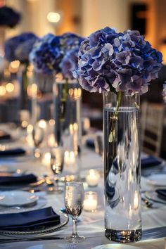 the table is set with blue flowers and candles