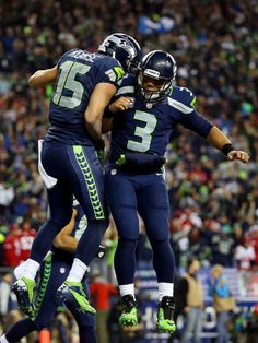 two football players are celebrating on the field