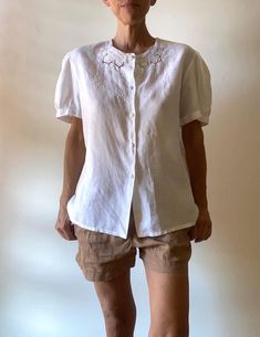 Very beautiful white shirt, made by a seamstress in 100% linen and hand embroidered. (label in Italian: "pure linen, hand embroidered" adorable details: the buttons covered with white fabric; a change button inside pretty puffed sleeves are also embroidered Size: Medium / Large Check with your measurements the model is a Small and measures 1m72 / 5.7' Shirt: - shoulder to shoulder 46 cm / 18" - bust 114 cm / 45" - length 68 cm / 27" Very good condition, fine and quality work **For shipping worldwide, phone number is required, thank you Delivery for France is free via Mondial Relais. Please specify your relay point in a message. Instagram for videos and news: @marinadeprovencevintage Spring Linen Top With Broderie Anglaise, Daywear Embroidered Linen Blouse, Embroidered Linen Blouse For Daywear, Linen Embroidered Button-up Top, Embroidered Linen Button-up Top, Linen Button-up Top With Embroidery, Fitted Linen Blouse With Floral Embroidery, White Linen Top With Broderie Anglaise, White Linen Top With Broderie Anglaise Detail