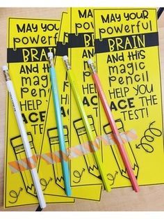 three pencils sitting next to each other on top of yellow paper