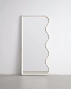 a white square shaped object sitting on top of a table next to a wall mounted mirror