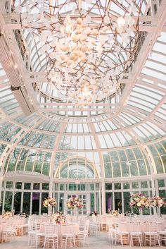 the inside of a building with tables and chairs set up for a formal function in front of large windows