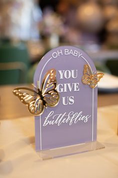 a purple sign with two butterflies on it that says, oh baby you give us bullfinishes