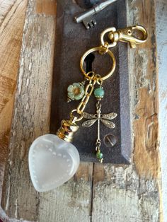 a glass keychain with a dragonfly charm hanging from it's side