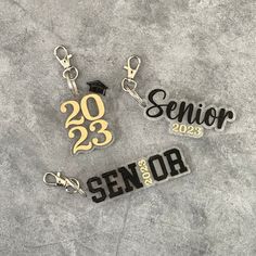 three keychains with the words senior and graduation written on them, sitting next to each other