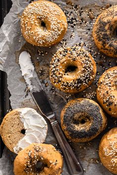 bagels with white frosting and sprinkles are on a baking sheet