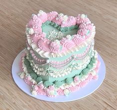 a heart shaped cake sitting on top of a white plate next to a wooden table