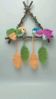 three colorful birds are hanging on a branch