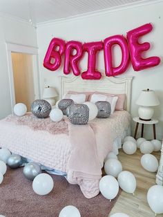 a bedroom decorated with balloons and the word bride spelled out in large letters on the wall