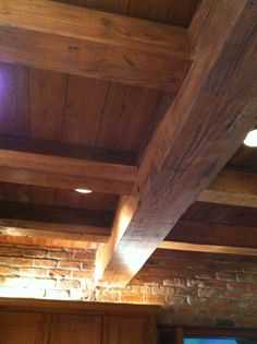 the ceiling is made of wood and has exposed beams on it, along with brick walls