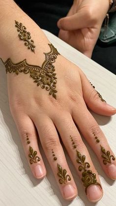 a woman's hand with henna tattoos on it