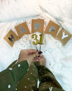 a person is holding a birthday candle in front of a number thirteen sign that reads happy 13th