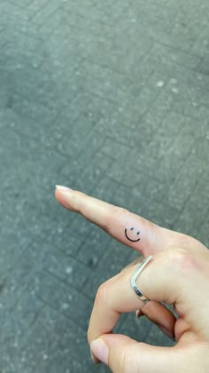 a person's finger with a smiley face drawn on it