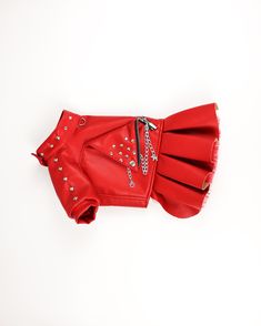 a red leather jacket with silver studs on the collar and cuffs, sitting on a white surface