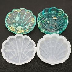 three seashell molds sitting on top of a black table next to each other