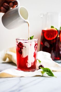 someone is pouring red liquid into a glass