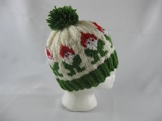 a white and green knitted hat with pom - poms on it's head