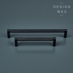 two black metal handles on a gray background with the words design max above them and below it