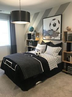 a bedroom decorated in black and white with a soccer theme on the wall above the bed